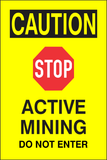Yellow caution sign reading “Active Mining – Do Not Enter,” used to warn workers and visitors of a hazardous mining area.