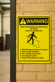 Warning sign on a brick wall advising safety measures for using stairs.