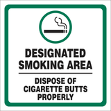 A safety sign with a green background, white text, and a cigarette in a prohibited symbol icon, indicating a designated smoking area with a request to dispose of cigarette butts properly.
