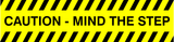 A yellow and black caution sticker with text 'CAUTION - MIND THE STEP' on a striped background.